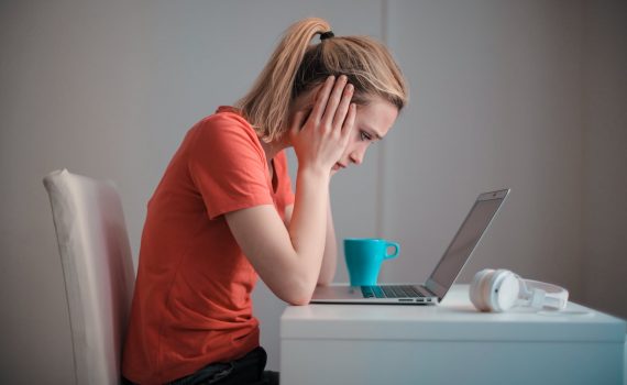 young troubled woman using laptop at home