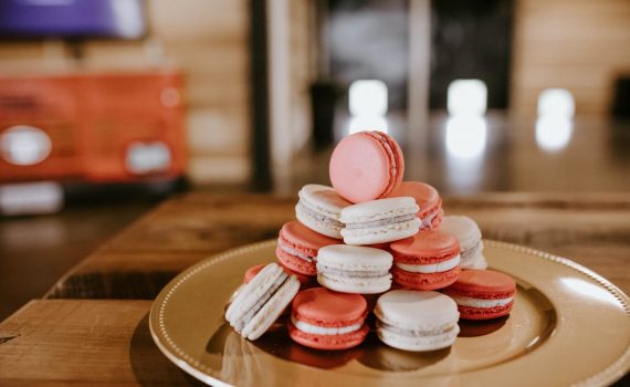 sweet macaroons on round plate on wooden table