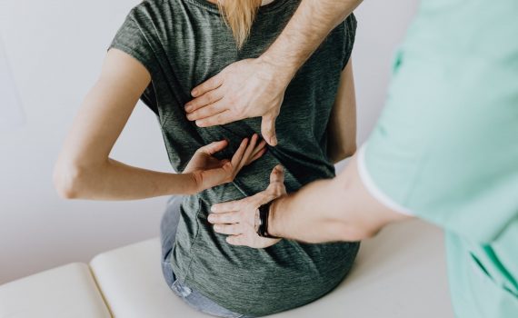 crop unrecognizable woman showing chiropractor painful spot on back