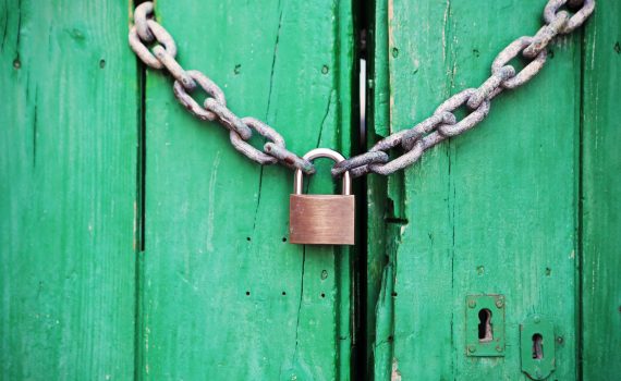 brass colored metal padlock with chain