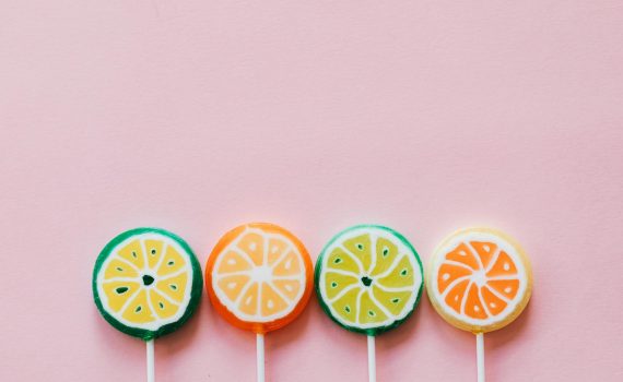 assorted colorful lollipops on pink background