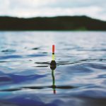 red yellow and black bouy on body of water during daytime