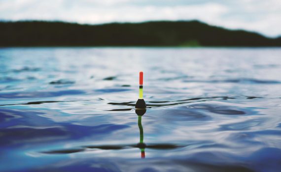 red yellow and black bouy on body of water during daytime